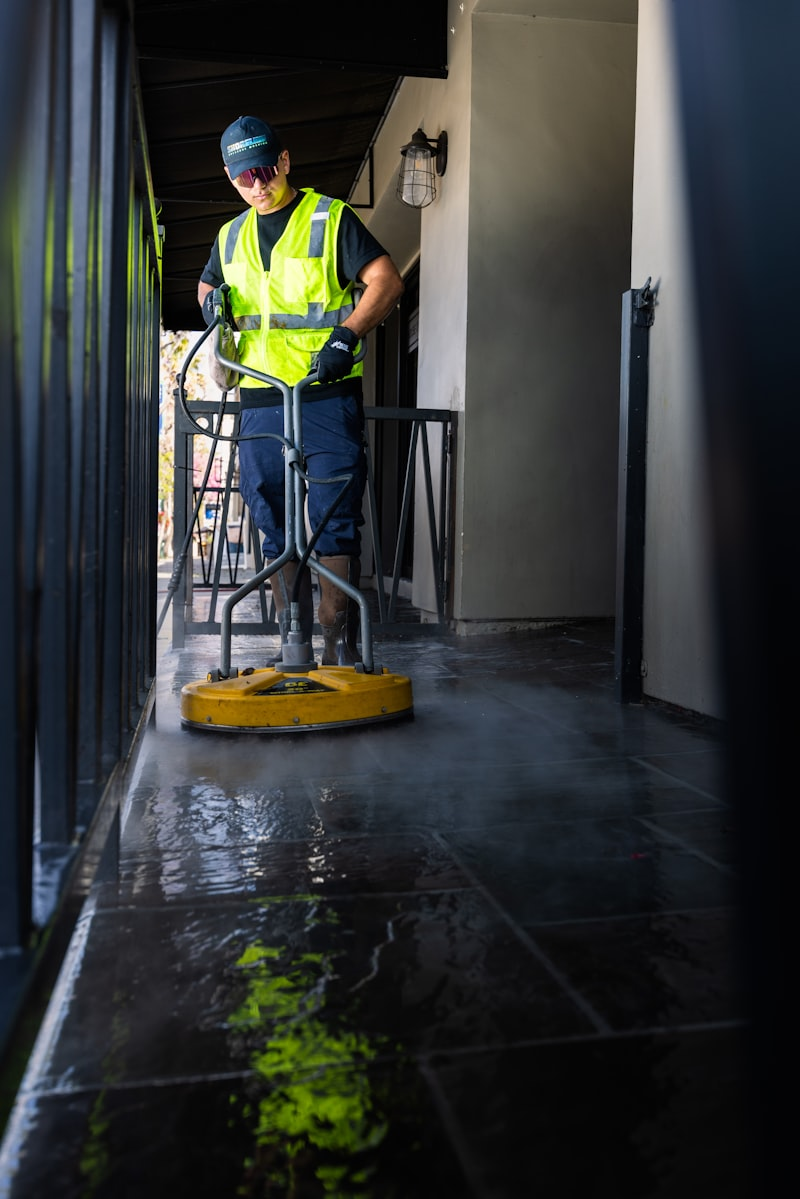 Man pressure washing home exterior
