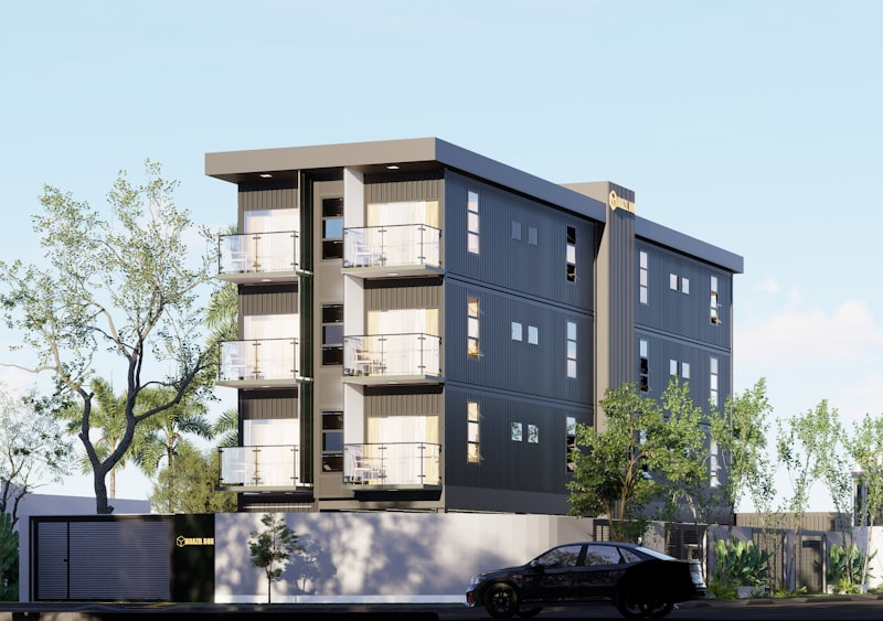 Modern apartment building with balconies and trees well-maintained rental property